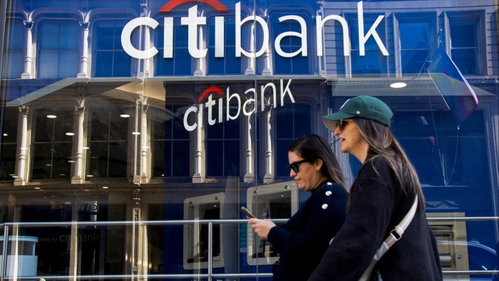 People walk by a Citibank building