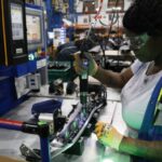 An employee installs lights in an instrument panel at the Dakkota Integrated Systems manufacturing facility in Detroit