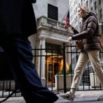 A pedestrian walks past the New York Stock Exchange