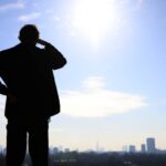 The sun shines on a person looking at the London skyline