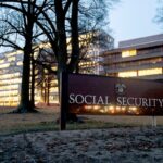 a photo of the U.S. Social Security Administration headquarters at night, with lights on across a series of floors of a building in Maryland