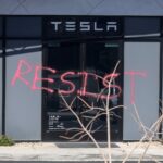 The word "RESIST" is shown spray painted on the entrance of a Tesla Collision Center after an individual used incendiary devices to set several vehicles on fire on March 18, 2025 in Las Vegas, Nevada.