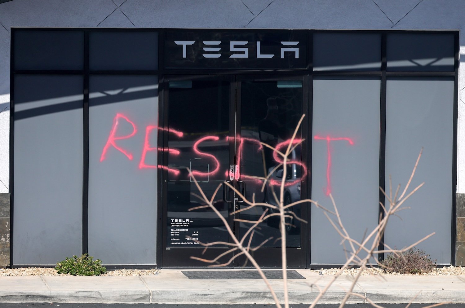 The word "RESIST" is shown spray painted on the entrance of a Tesla Collision Center after an individual used incendiary devices to set several vehicles on fire on March 18, 2025 in Las Vegas, Nevada.