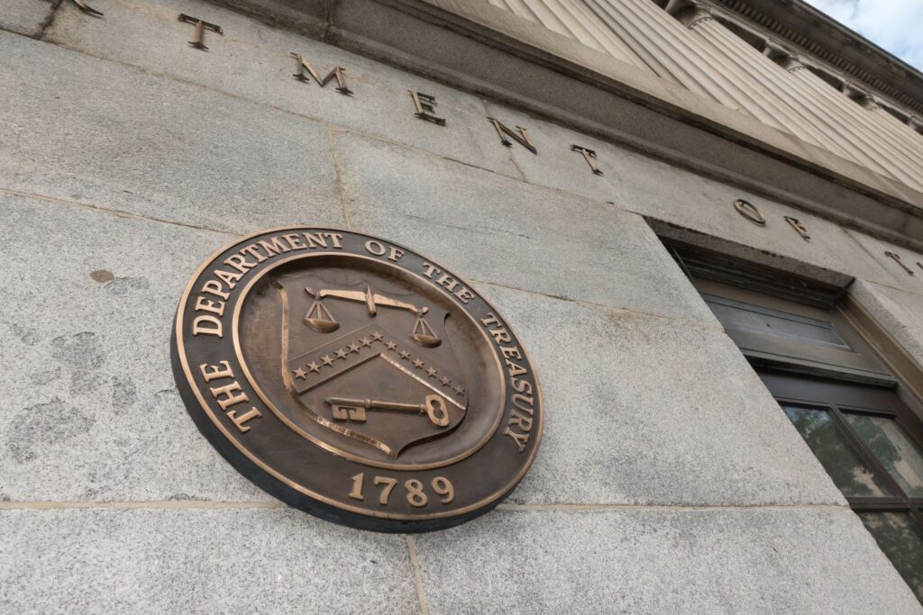 A low angle shot looking up at a building with the U.S. Treasury seal on it.