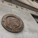 A low angle shot looking up at a building with the U.S. Treasury seal on it.